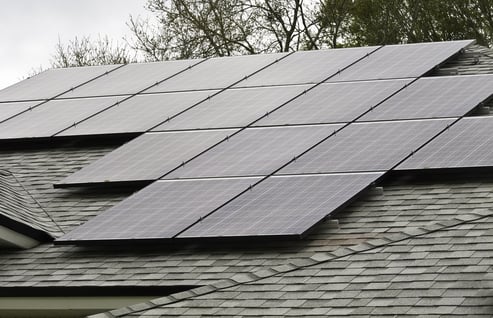 Array of solar panels on sloped roof of detached house on an overcast morning-1 Array of solar panels on sloped roof of detached house on an overcast morning-1