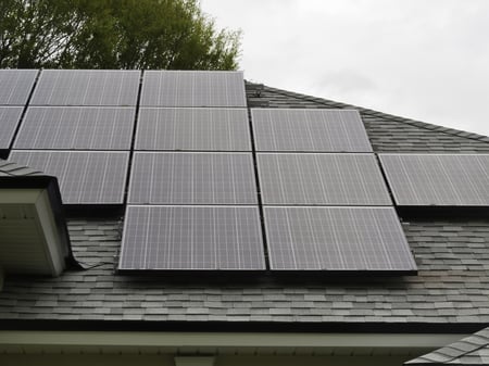 Solar panels on sloped roof of house on overcast day Solar panels on sloped roof of house on overcast day